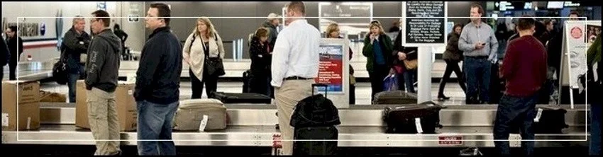 Private investigator photo of people standing by luggage pick up at the Houston airport.