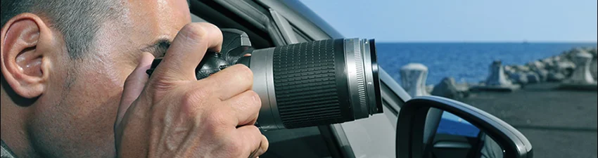 Private investigator taking a photo from his car during a family investigation.